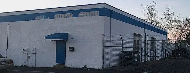The 311 Garage building on Old Orems Road: white block walls, a blue band and a blue awning over the door